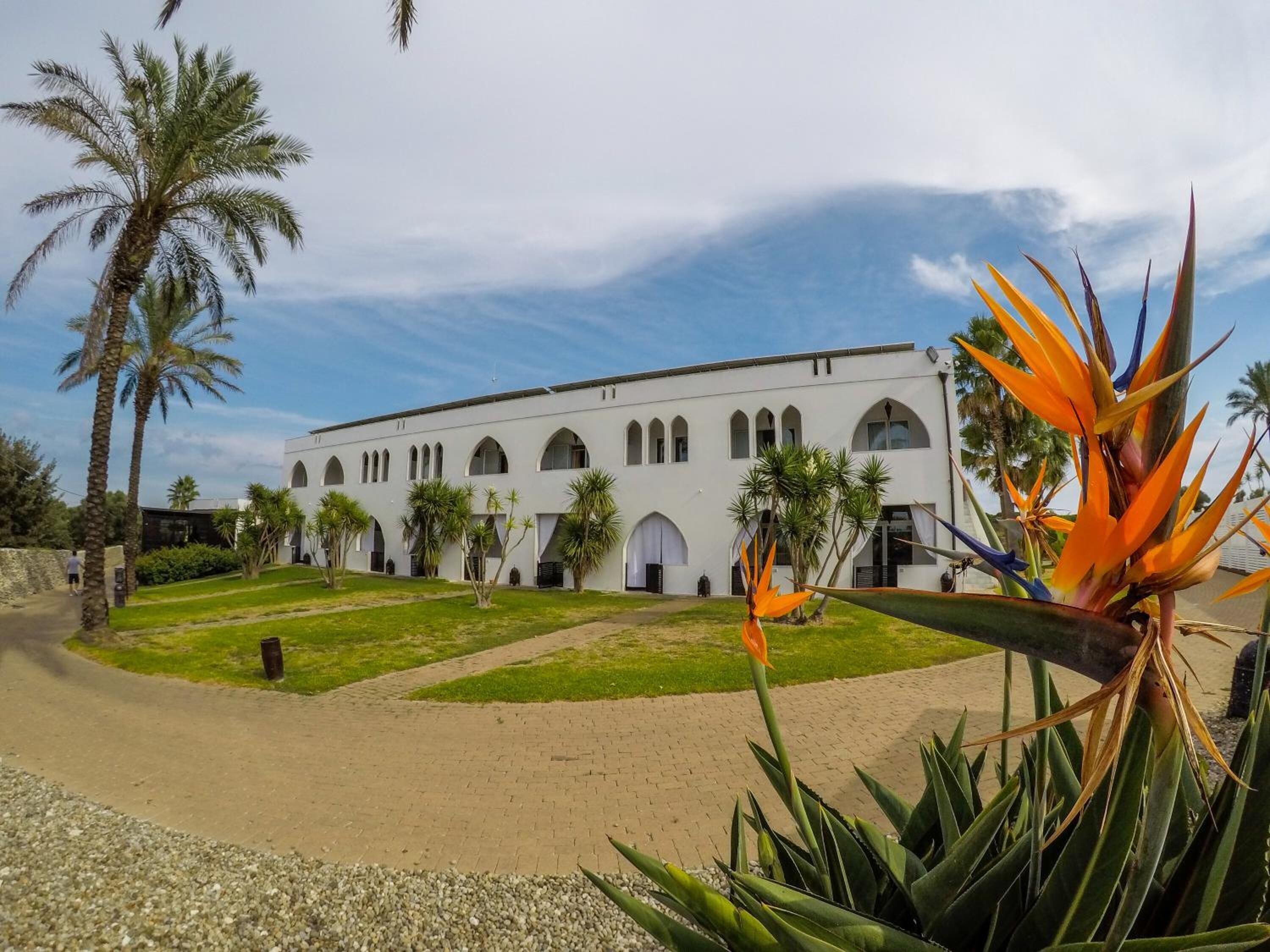 A white building with arched windows and a central courtyard.