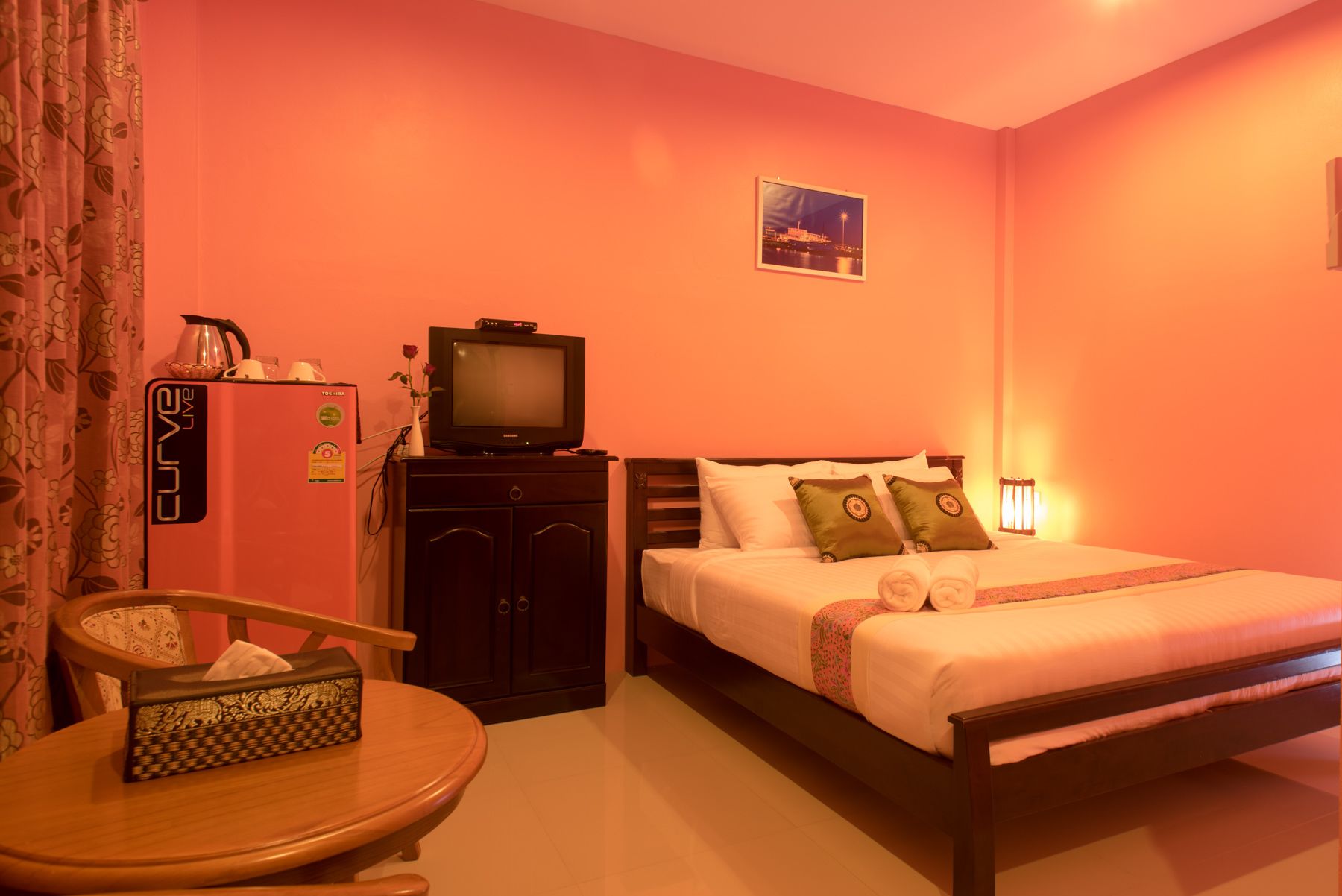 A hotel room with a bed, a TV, a desk, and a chair.