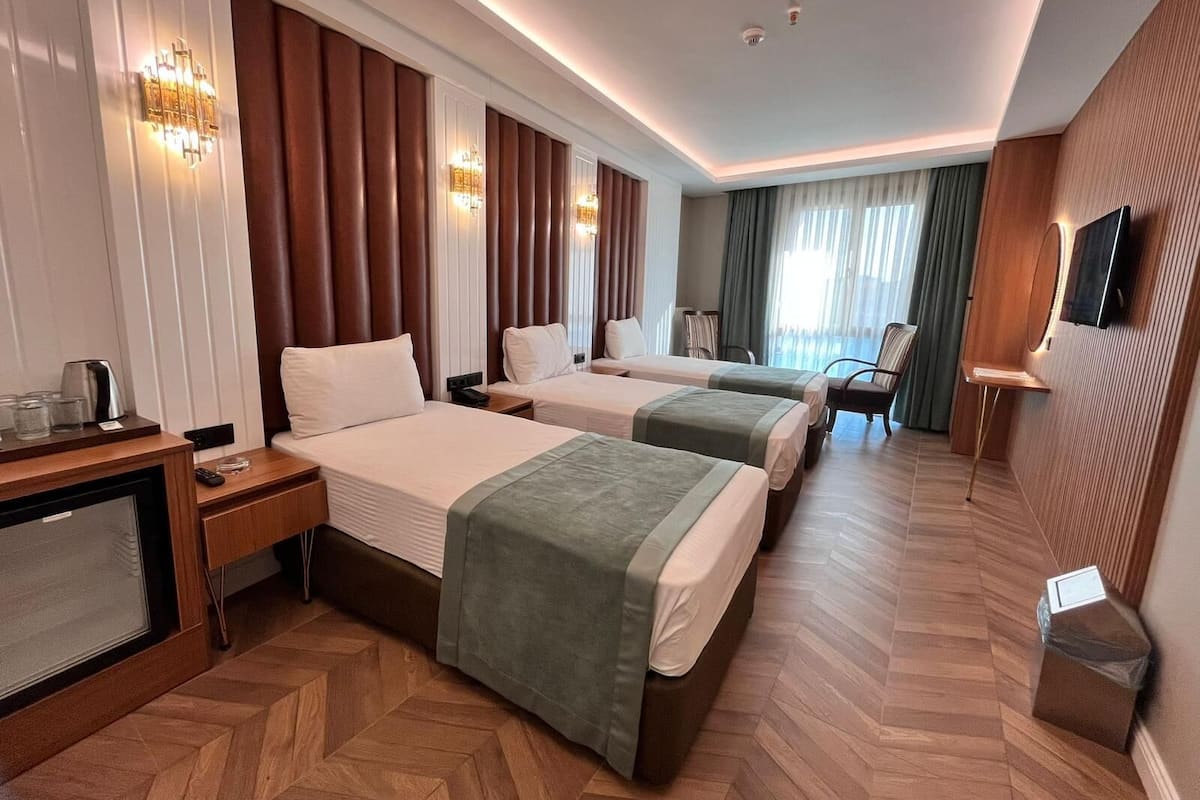 Deluxe driepersoonskamer | Luxe beddengoed, een minibar, een kluis op de kamer