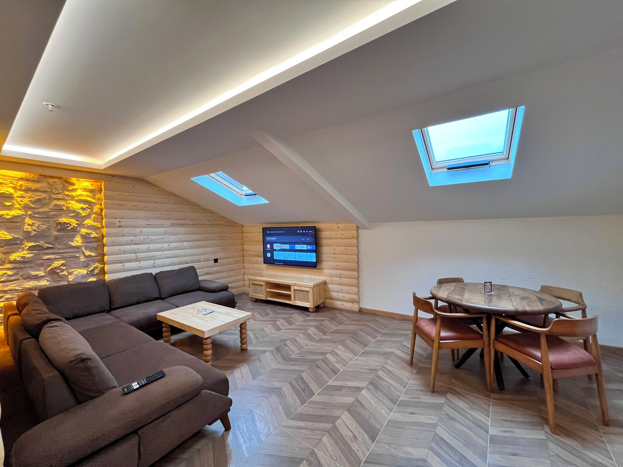 Een moderne woonkamer in loftstijl met een bank, salontafel en eettafel.