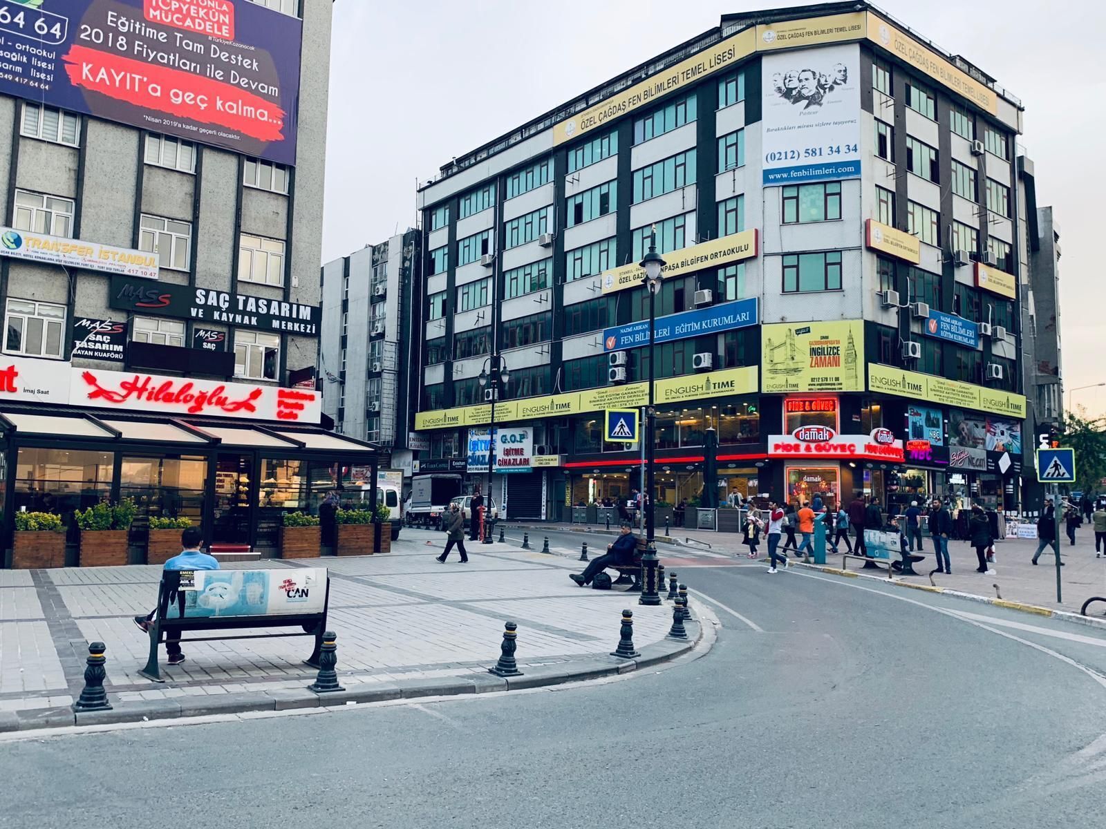 A multi-story building with various commercial establishments on the ground floor, including a restaurant and a hotel.