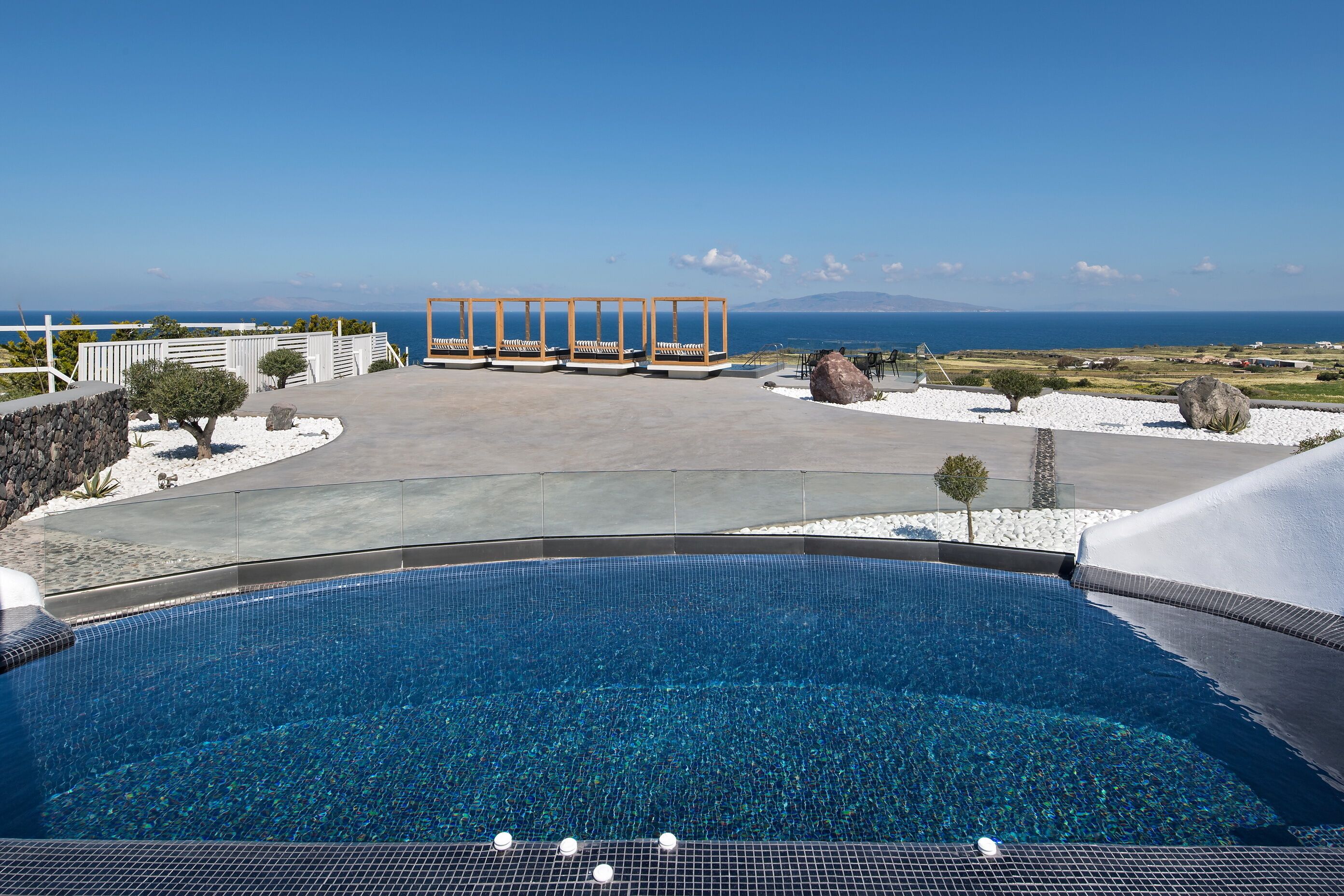 A pool with a clear view of the sea and mountains in the background.
