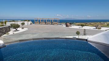 A pool with a clear view of the sea and mountains in the background.