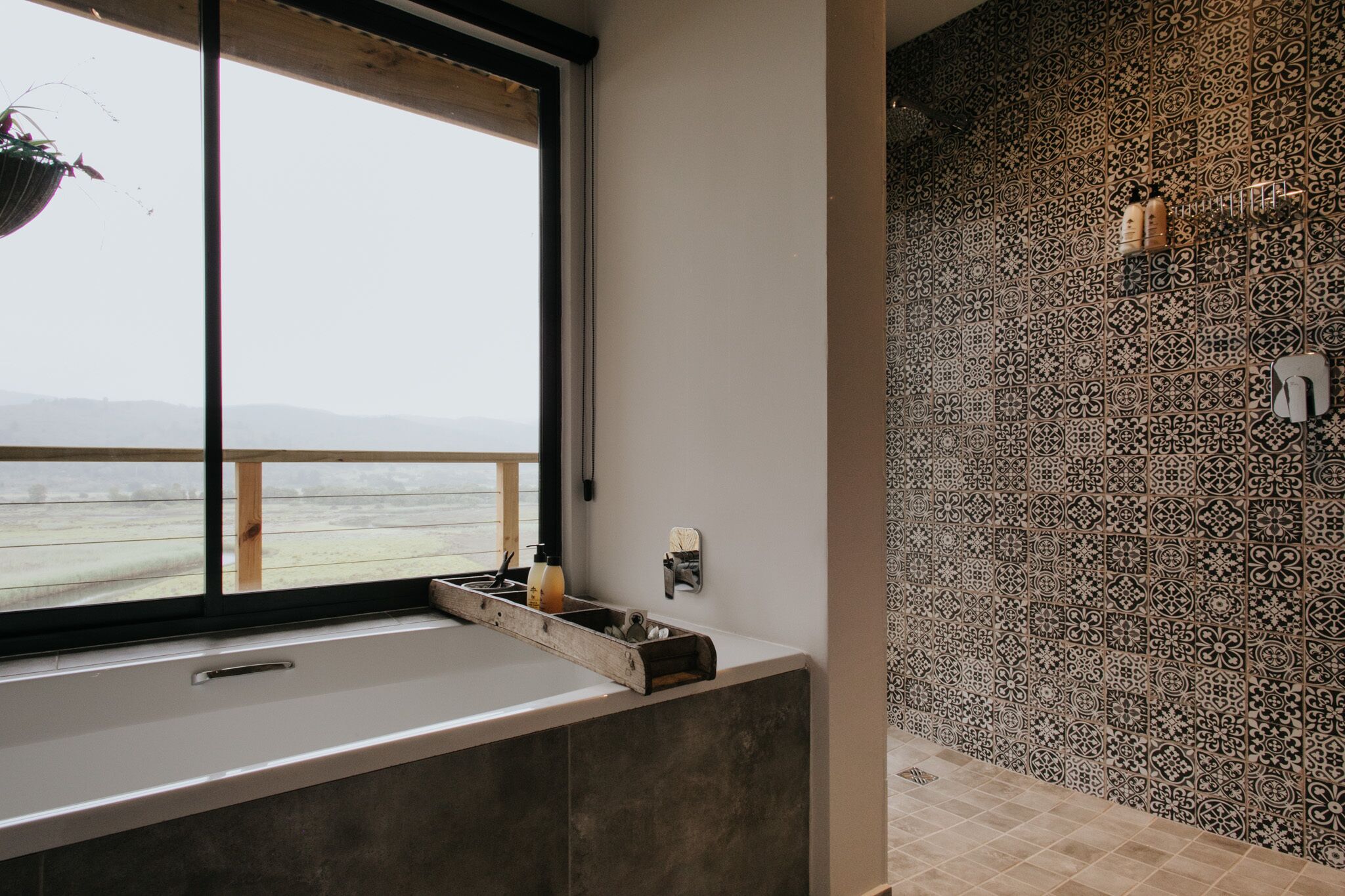 Een moderne badkamer met een groot bad, een raam met uitzicht en een behangen muur.