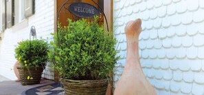 A welcome sign, a wicker basket with greenery, and a large vase. - Gasthof Blume (Oppenau)