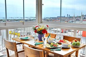 A dining table with a view of a cityscape through large windows. - Hotel Davos (Istanbul)