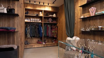 Interior de madera con estantes que exhiben bolsos, joyas y ropa.