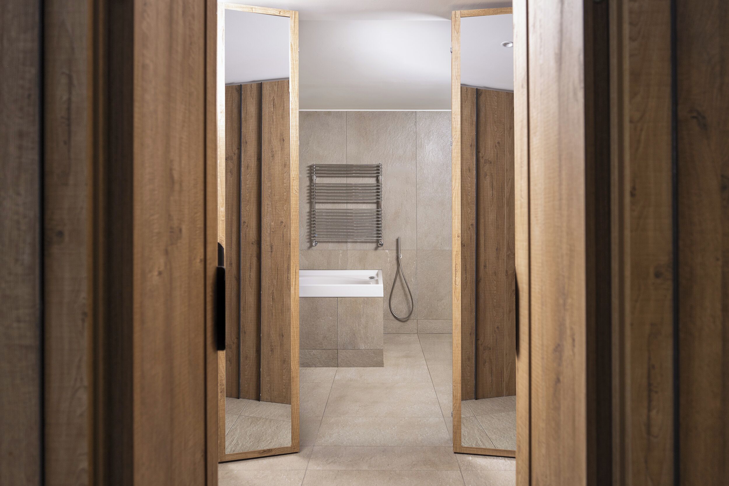A wooden-framed bathroom with a shower, a towel rack, and a bathtub.