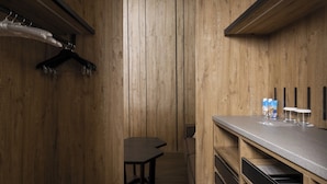 Una habitación con paneles de madera, una mesa, un banco y una barra con vasos y botellas.