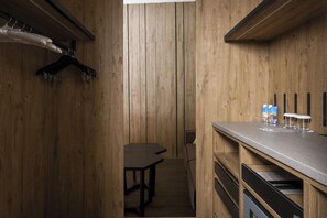 A wooden-paneled room with a table, a bench, and a counter with glasses and bottles. - Grand Hotel Courmayeur Montblanc by R Collection Hotels (Courmayeur)