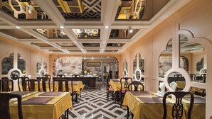 A dining area with tables and chairs, a patterned floor, and a ceiling with recessed lighting. - Hanoi Little Town Hotel (Hanoi)