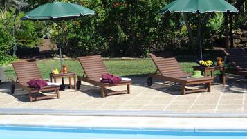 Una piscina cubierta, una piscina al aire libre, sombrillas, tumbonas