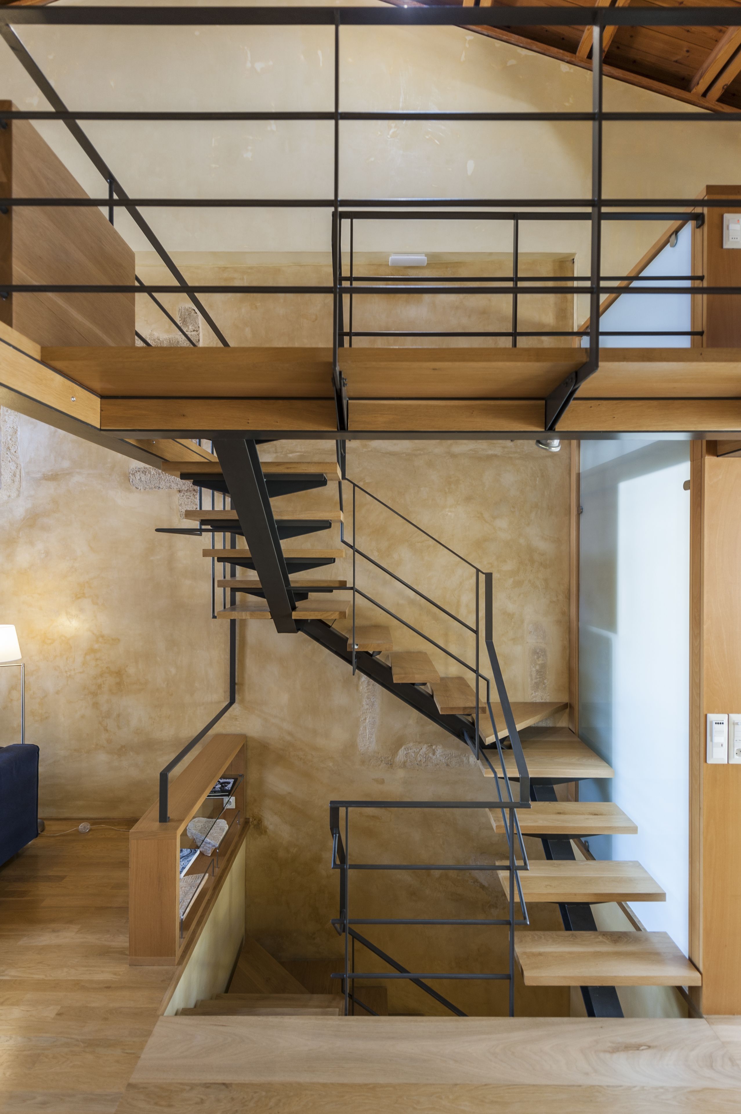 Un intérieur moderne avec un escalier en bois et un banc intégré.