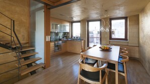 Eine moderne Küche mit Holzschränken und einem Essbereich mit Holztisch und Stühlen.