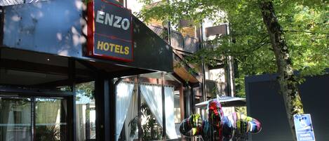 Un cartel de hotel con el nombre "ENZO HOTELS" y una escultura decorativa en el exterior.