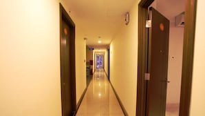 A hotel hallway with doors on both sides, a tiled floor, and a light-colored wall. - Galaxy Hotel Phu Quoc (Phu Quoc)
