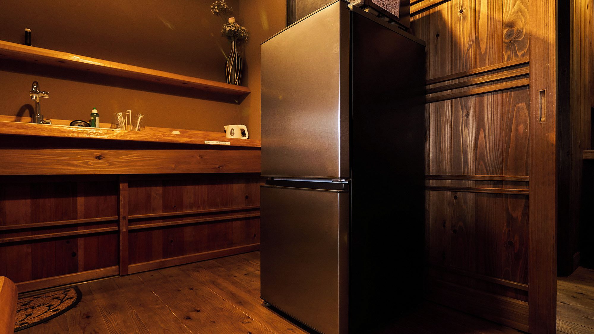 Una cocina con refrigerador de acero inoxidable, armarios de madera y encimera de madera.