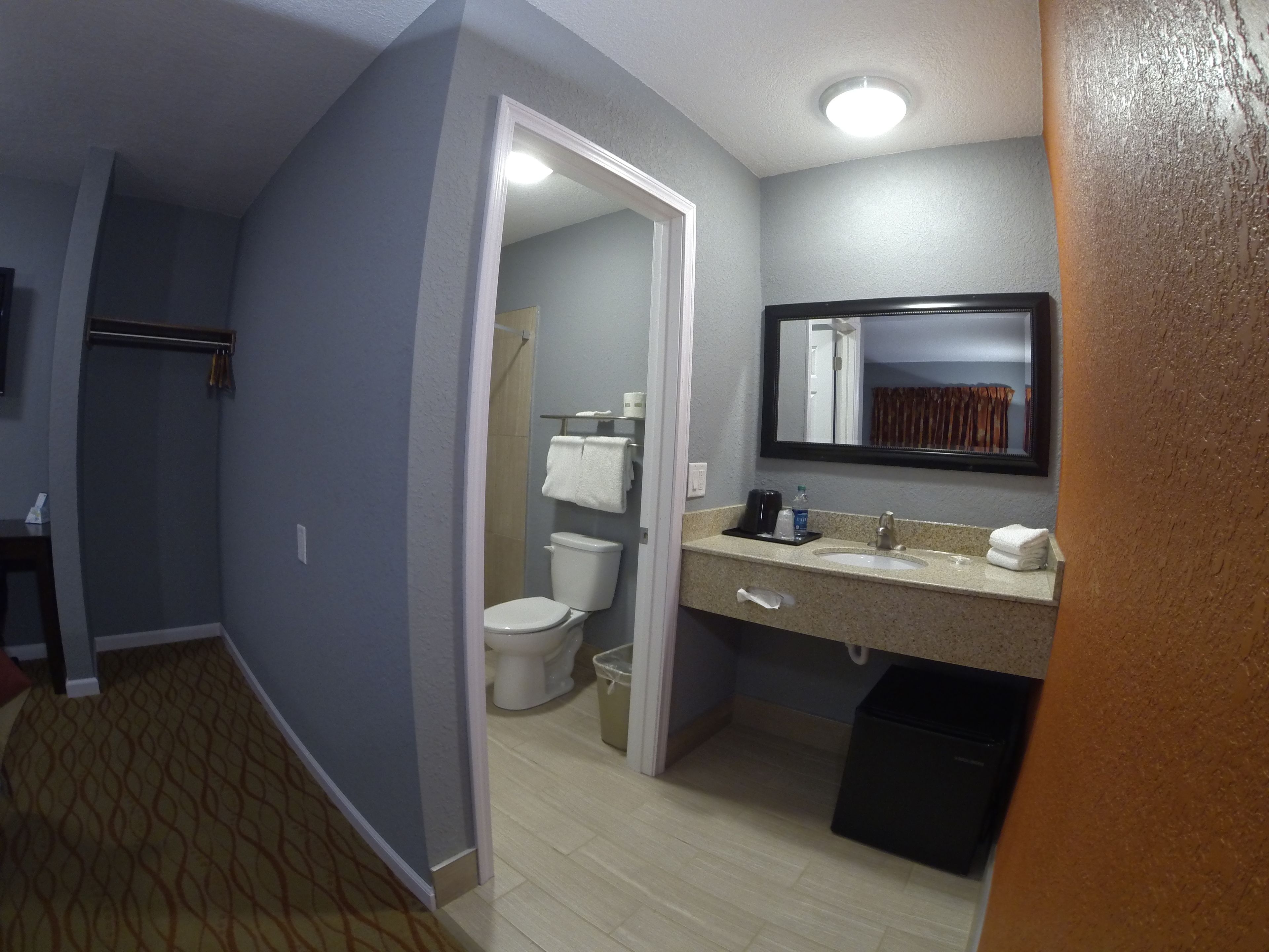 Une salle de bain d’hôtel équipée de toilettes, d’un lavabo et d’un miroir.