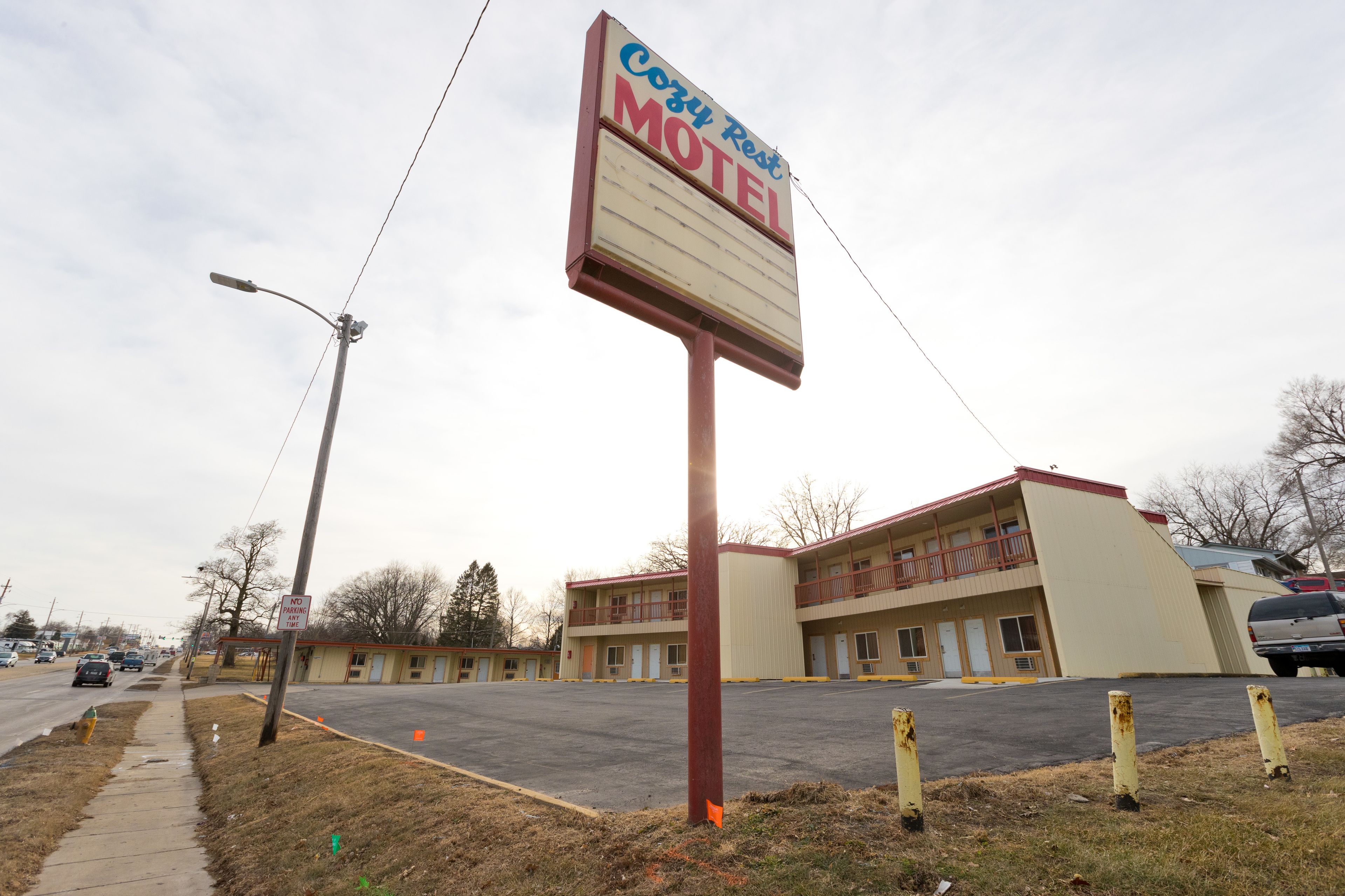 Un motel con un grande cartello, un parcheggio e un edificio su più piani.