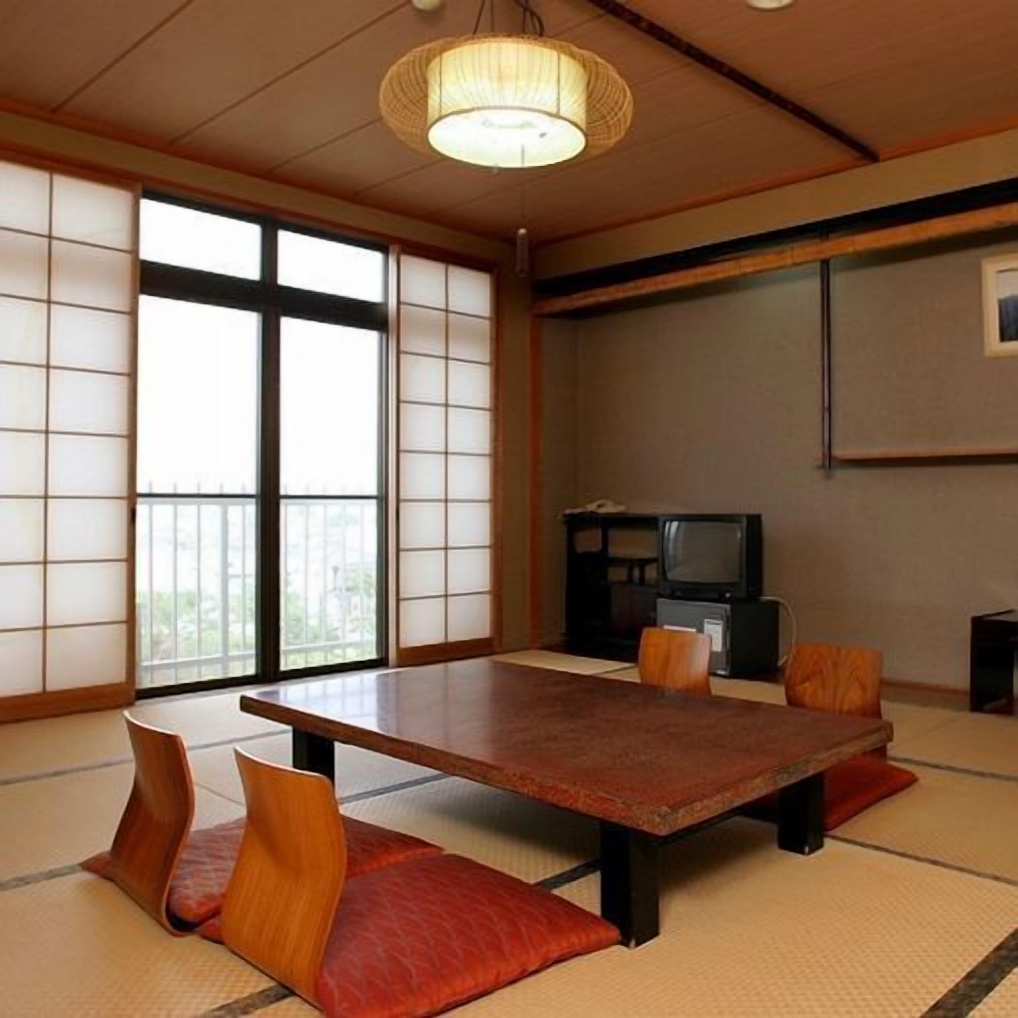 A traditional Japanese room with tatami flooring, a low table, and cushions.