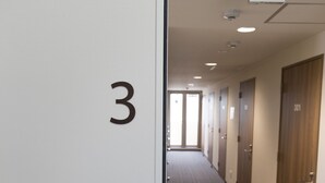 A hallway with a number '3' on the wall, leading to doors with a '301' marking.