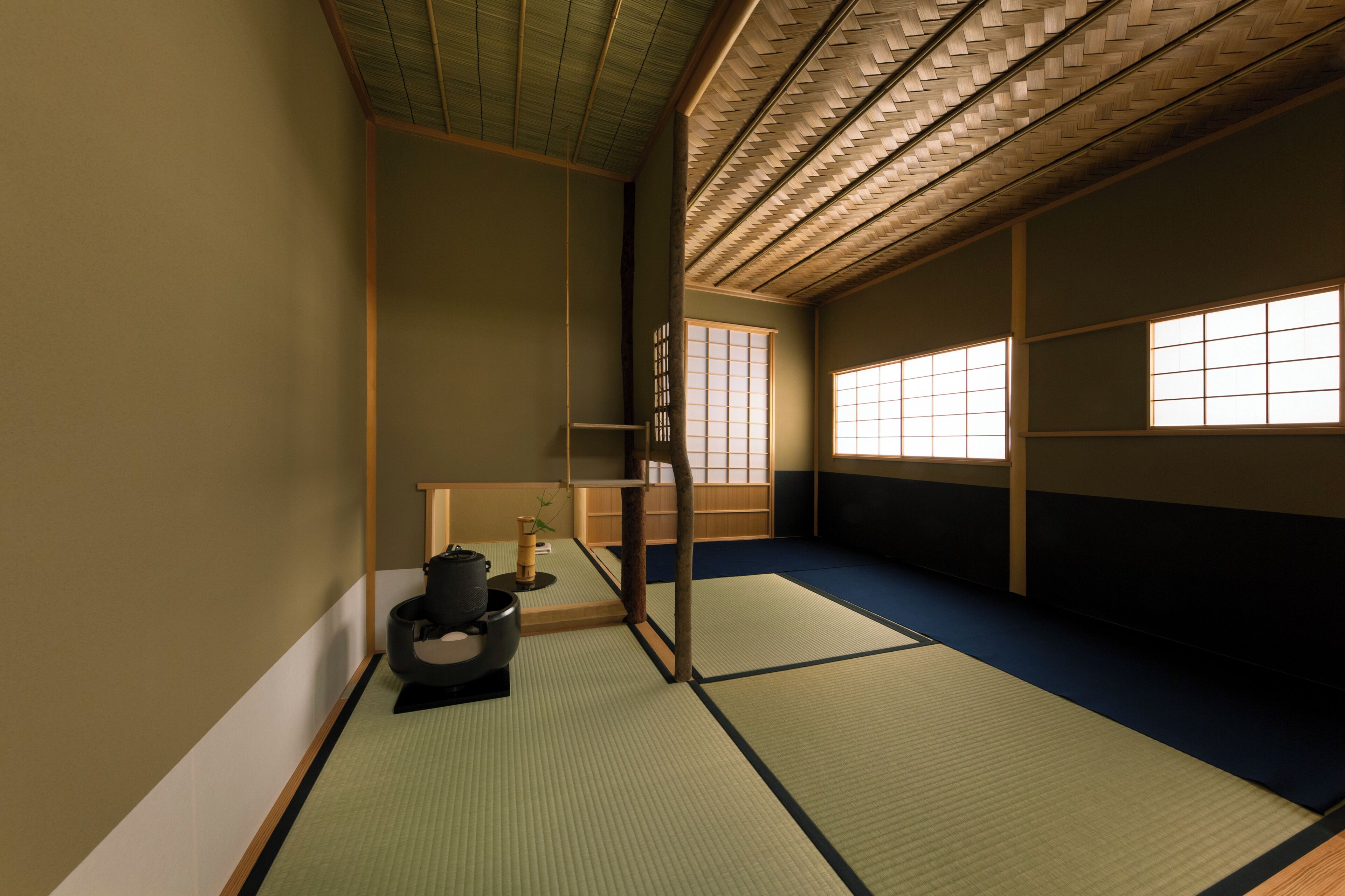 Una habitación japonesa tradicional con suelo de tatami, puertas correderas y techo bajo.