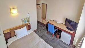 A hotel room with a bed, desk, television, and a small refrigerator. - Kadoma Public (Kadoma)
