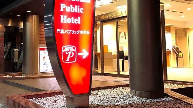 Segnaletica per l'Hotel Kadoma Public con una freccia direzionale.
