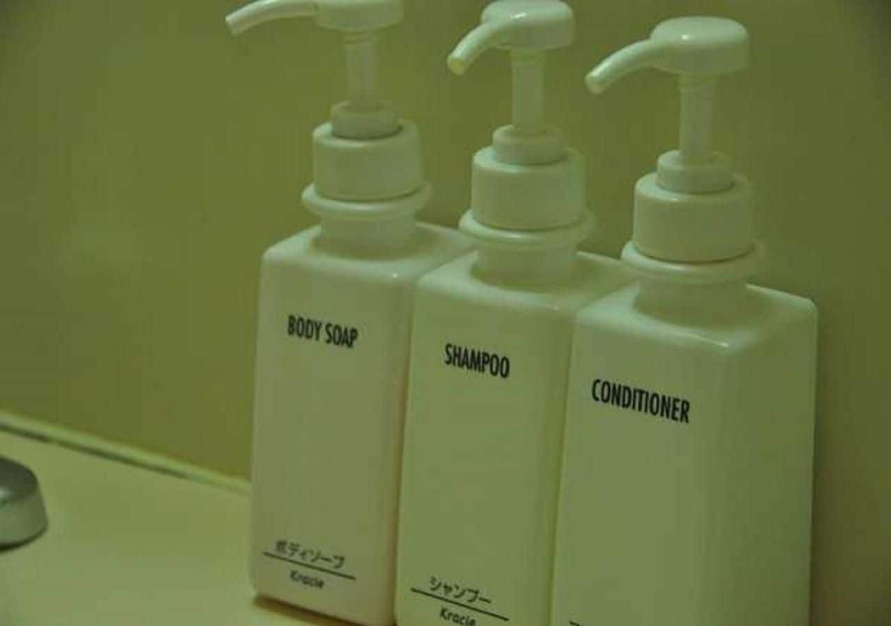 Three bottles of toiletries labeled body soap, shampoo, and conditioner.