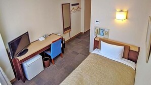 A hotel room with a bed, a desk with a computer, a small fridge, a mirror, and a wall-mounted phone. - Kadoma Public (Kadoma)