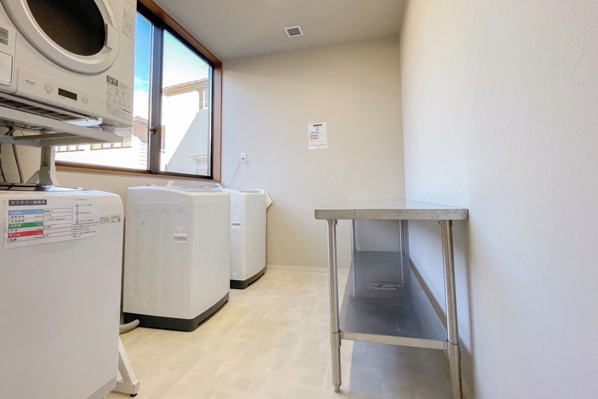 A laundry room with a washing machine, dryer, and a metal table.