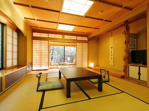 A traditional Japanese room with tatami flooring, a low table, and sliding doors. - Yufuin Yumeguri Hotel Sankouen (Yufu)