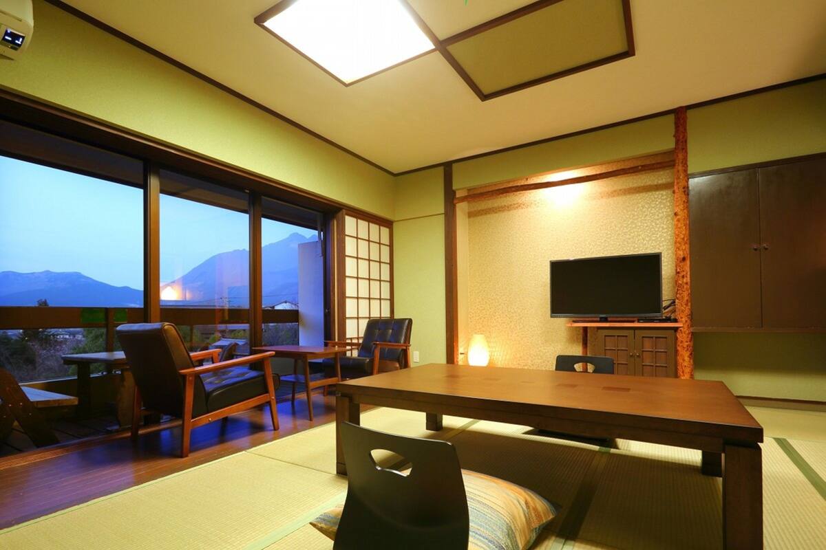 Una habitación japonesa tradicional con suelo de tatami, una mesa baja y sillas.