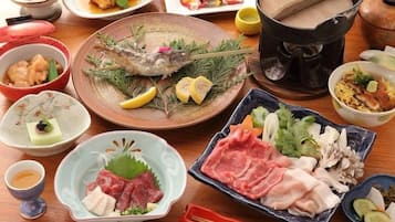 A variety of dishes including fish, meat, and vegetables, suggesting a meal setting.