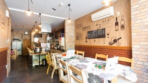 Ravintola, jossa on tiiliseinät, puupöydät ja katosta roikkuvat valaisimet.