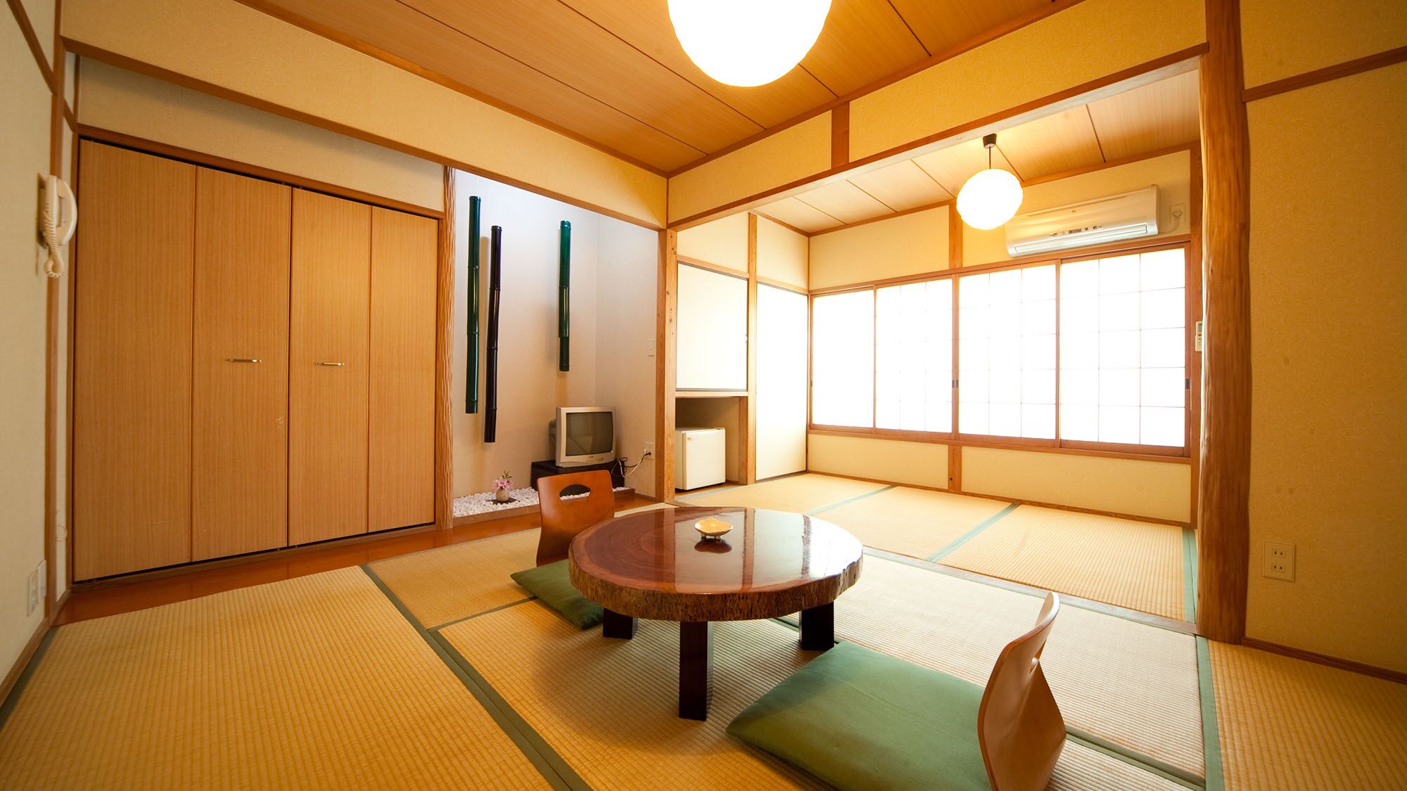A traditional Japanese room with tatami flooring, a low table, and sliding doors.