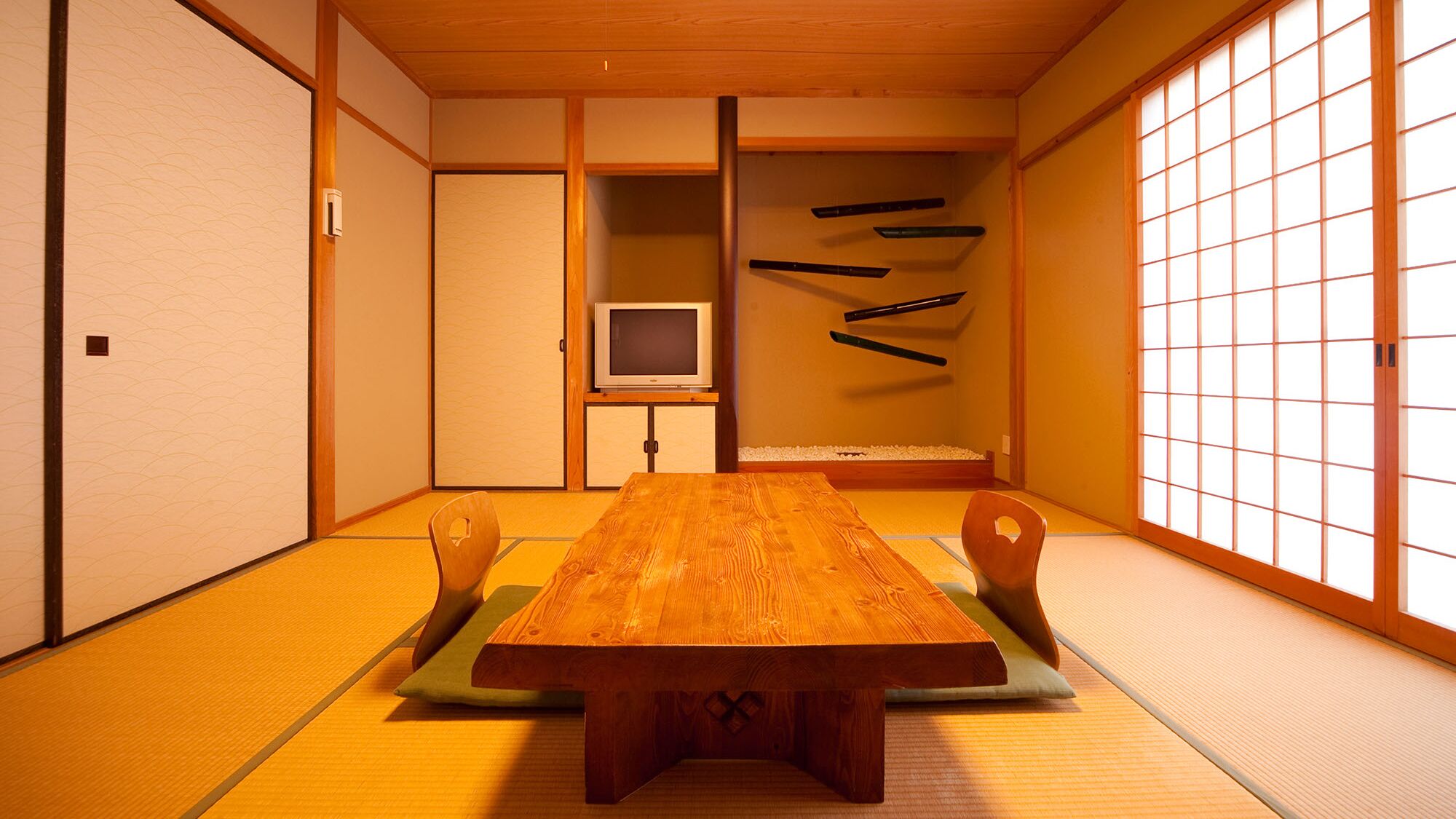 A traditional Japanese room with tatami flooring, a low wooden table, and sliding doors.