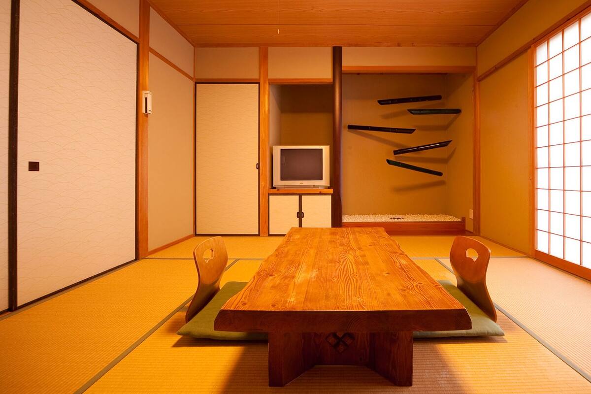 A traditional Japanese room with tatami flooring, a low wooden table, and sliding doors.