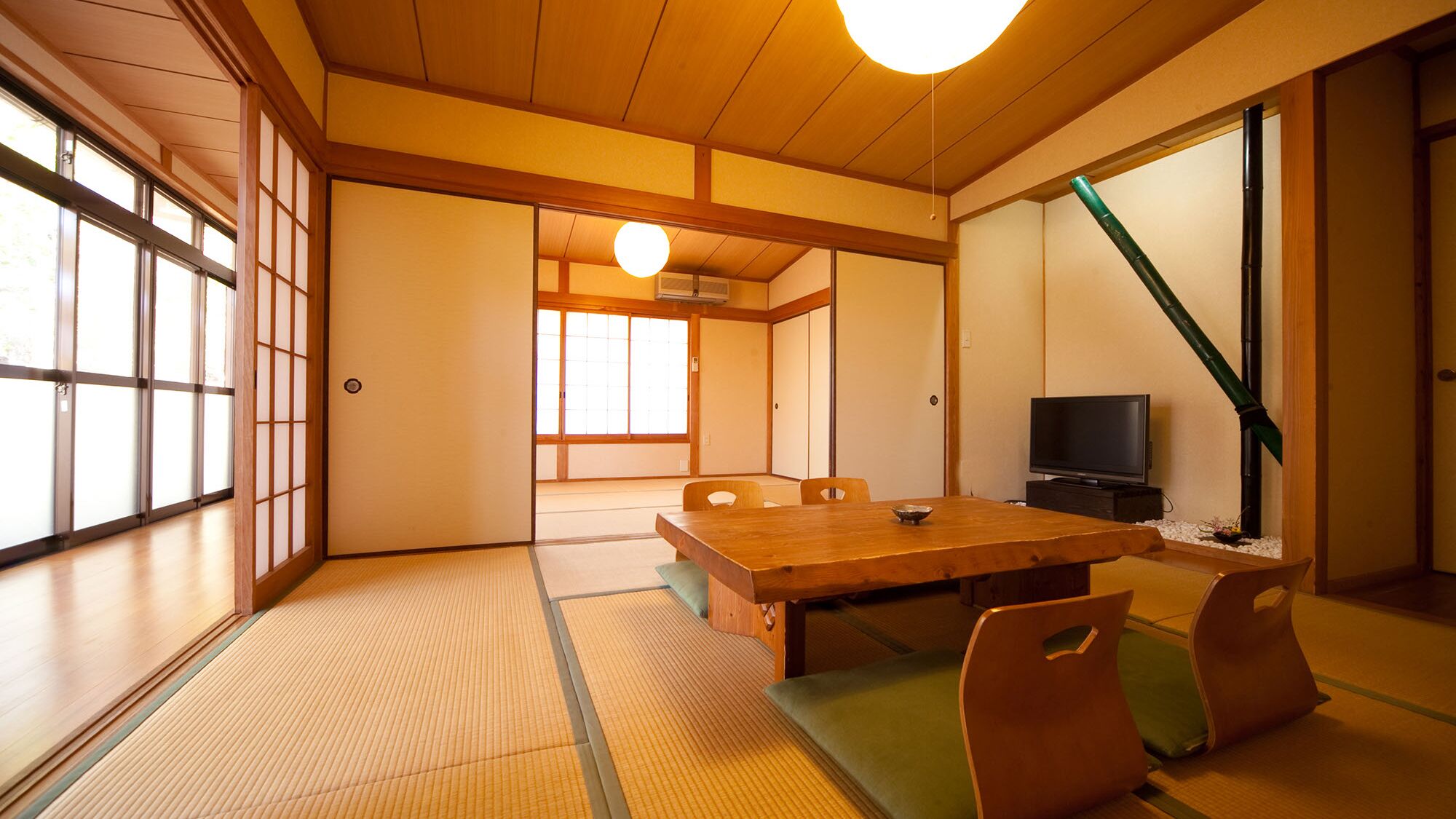 A traditional Japanese room with tatami flooring, a low table, and sliding doors.