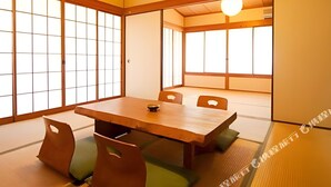 Una habitación tradicional japonesa con suelo de tatami, una mesa de madera baja y puertas correderas shoji.