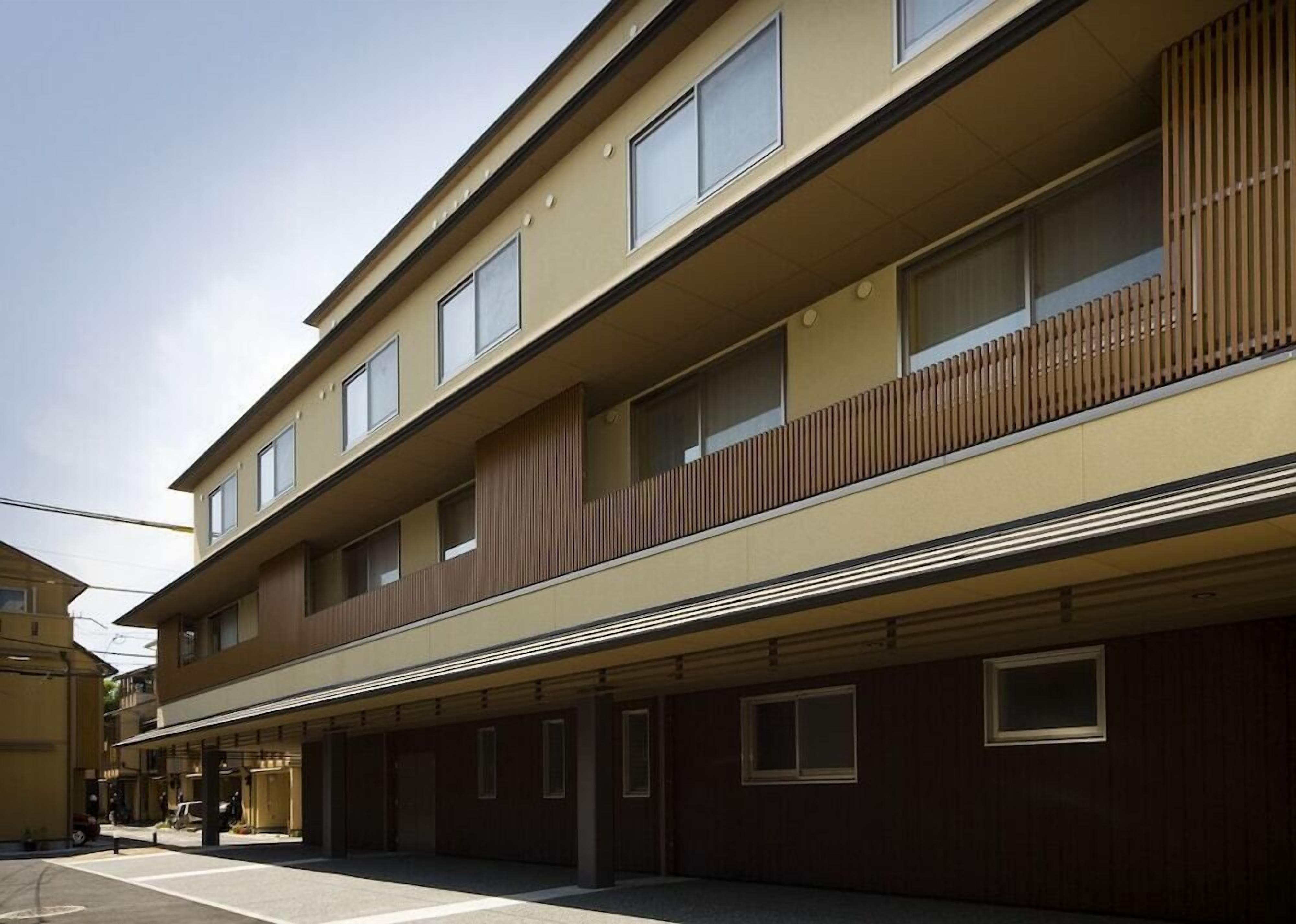 A multi-story building with a flat facade, large windows, and a covered entrance area.