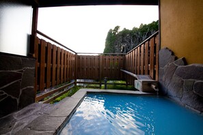Relax by the serene pool surrounded by a tranquil atmosphere and a small waterfall feature.