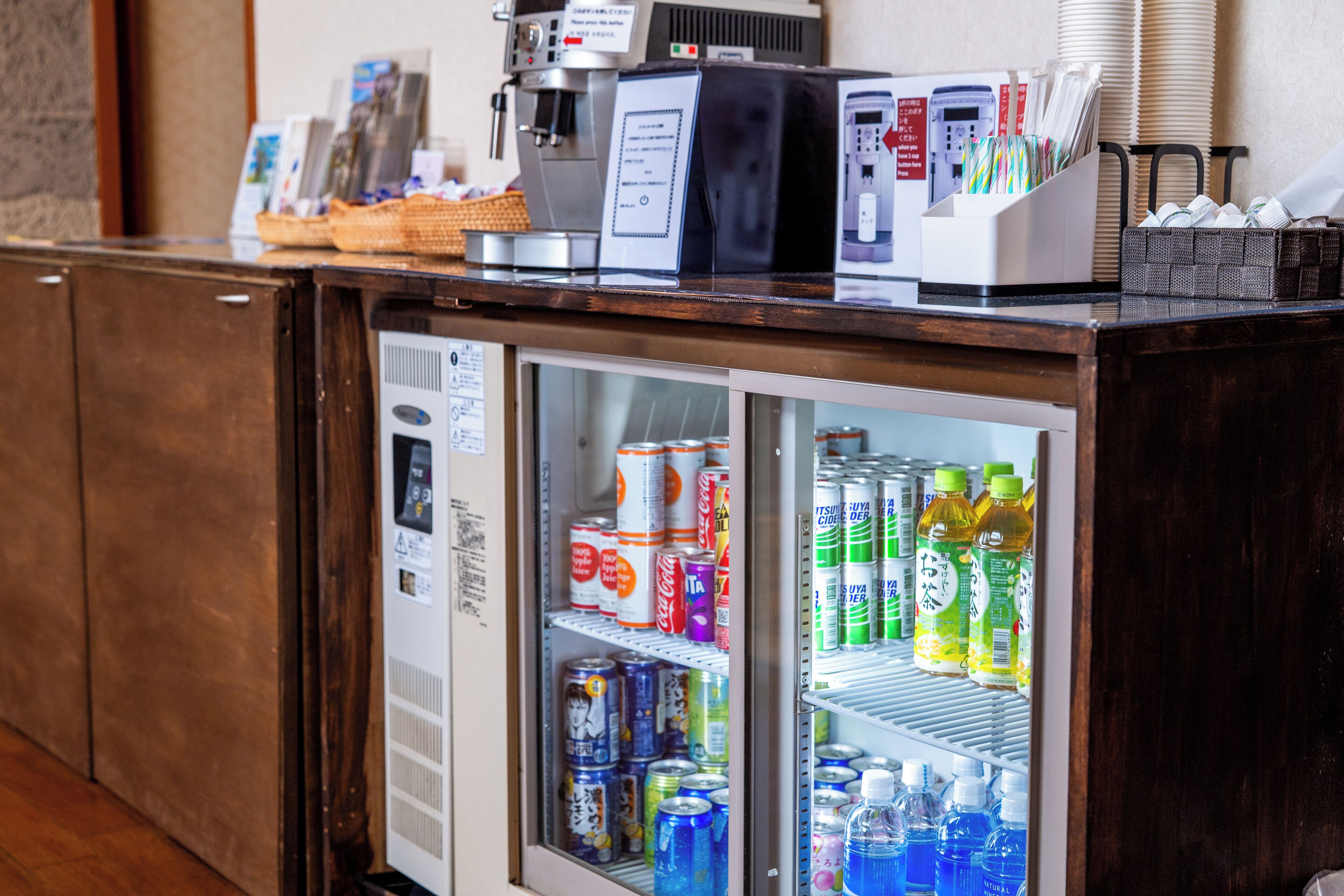 A refrigerator stocked with beverages and a coffee machine on top.