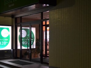 A building entrance with glass doors and a green signboard. - Good Inn Hayato (Kirishima)