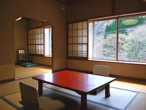 A traditional Japanese room with tatami flooring, a low table, and shoji screens. - Yugawara Onsen Kamata (Yugawara)