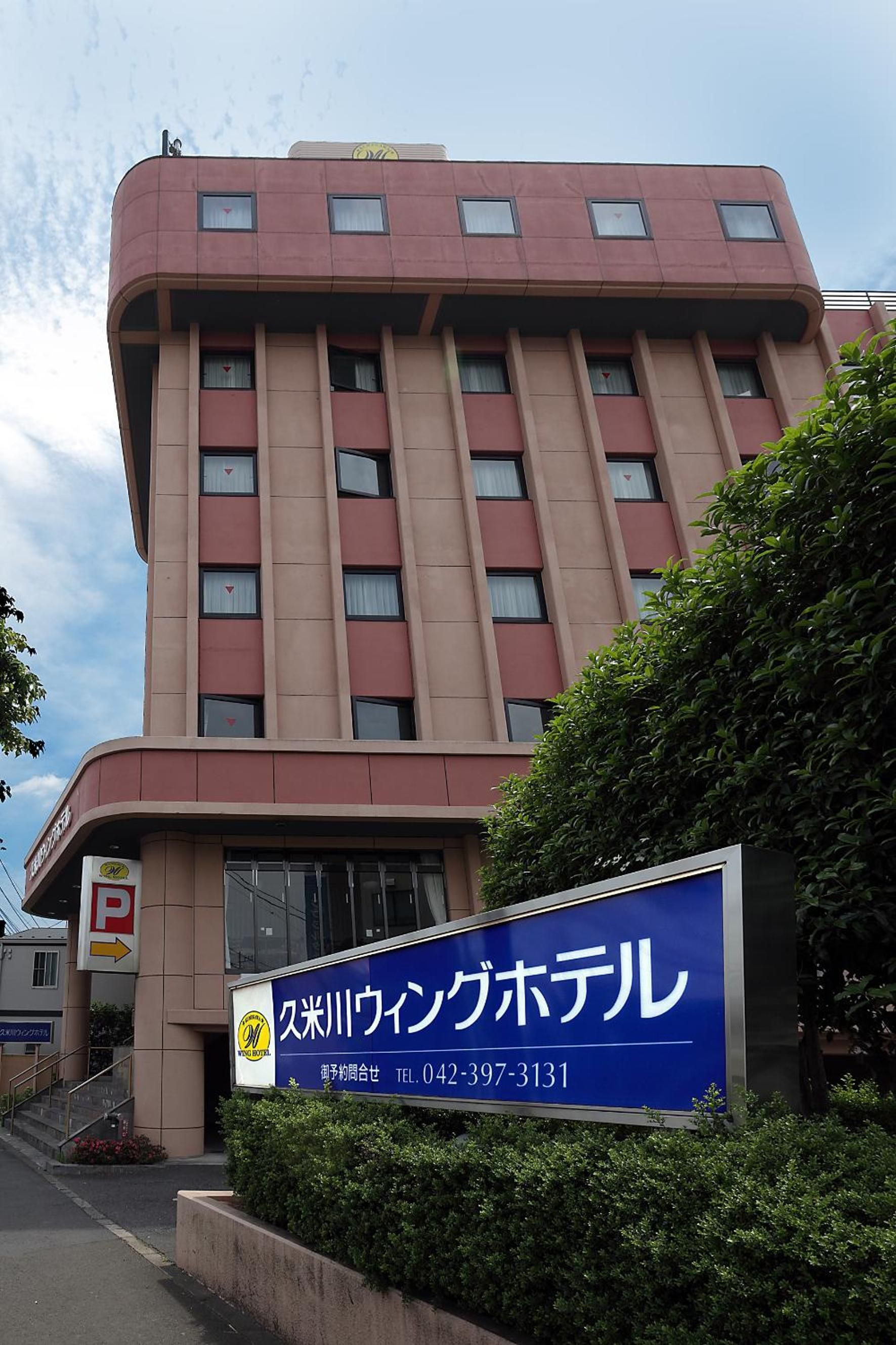 A hotel building with a sign indicating it is the 'Satsuki-Wan King Hotel.'