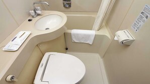 Un baño pequeño con lavamanos, inodoro y perchero para toallas.