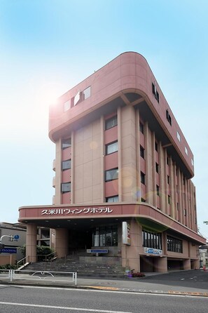 A multi-story building with a curved facade, a prominent entrance, and signage indicating it is a hotel. - Kumegawa Wing Hotel (Higashimurayama)