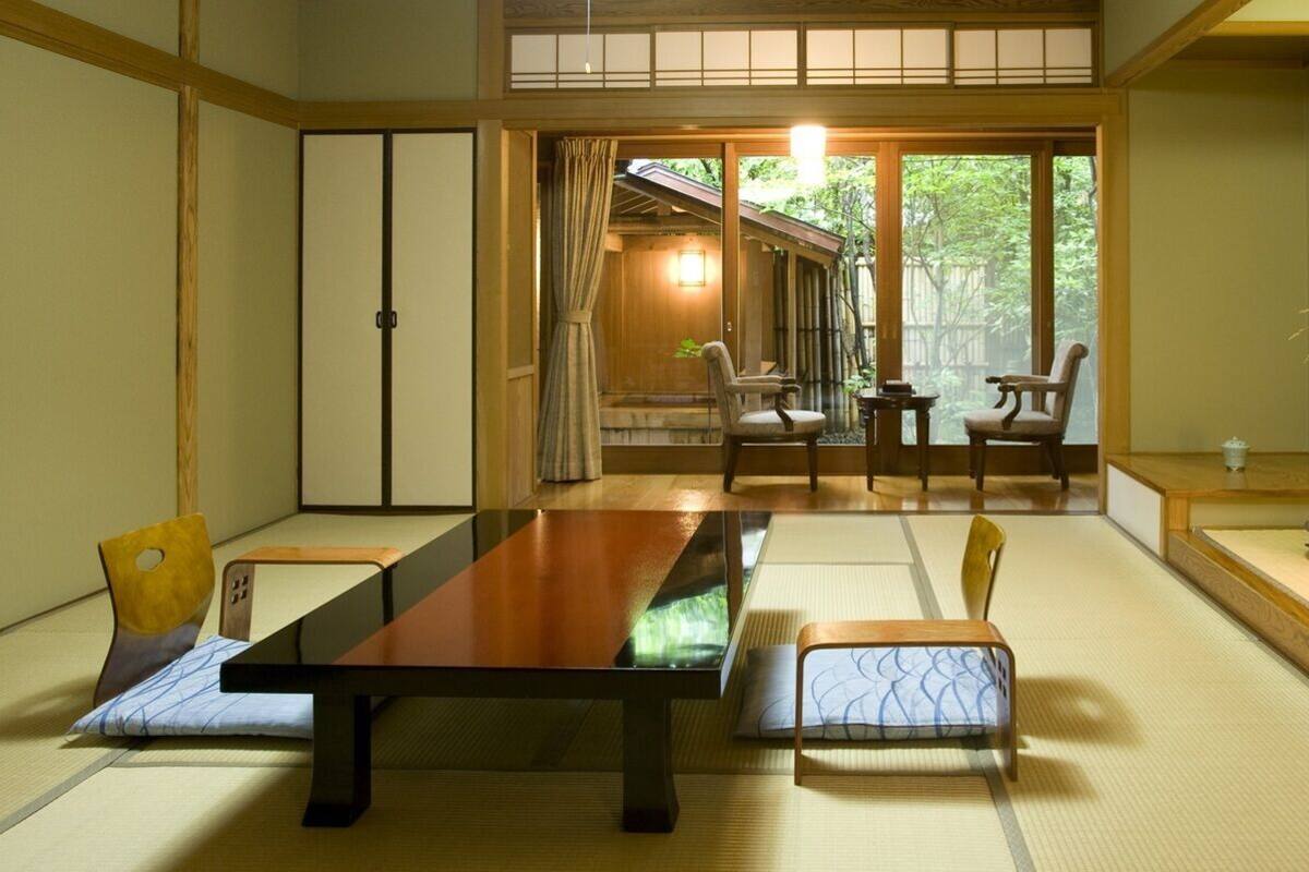 Ein traditioneller japanischer Raum mit Tatami-Boden, einem niedrigen Tisch und Stühlen.