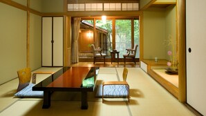 Ein traditioneller japanischer Raum mit Tatami-Böden, einem niedrigen Tisch und Schiebetüren.